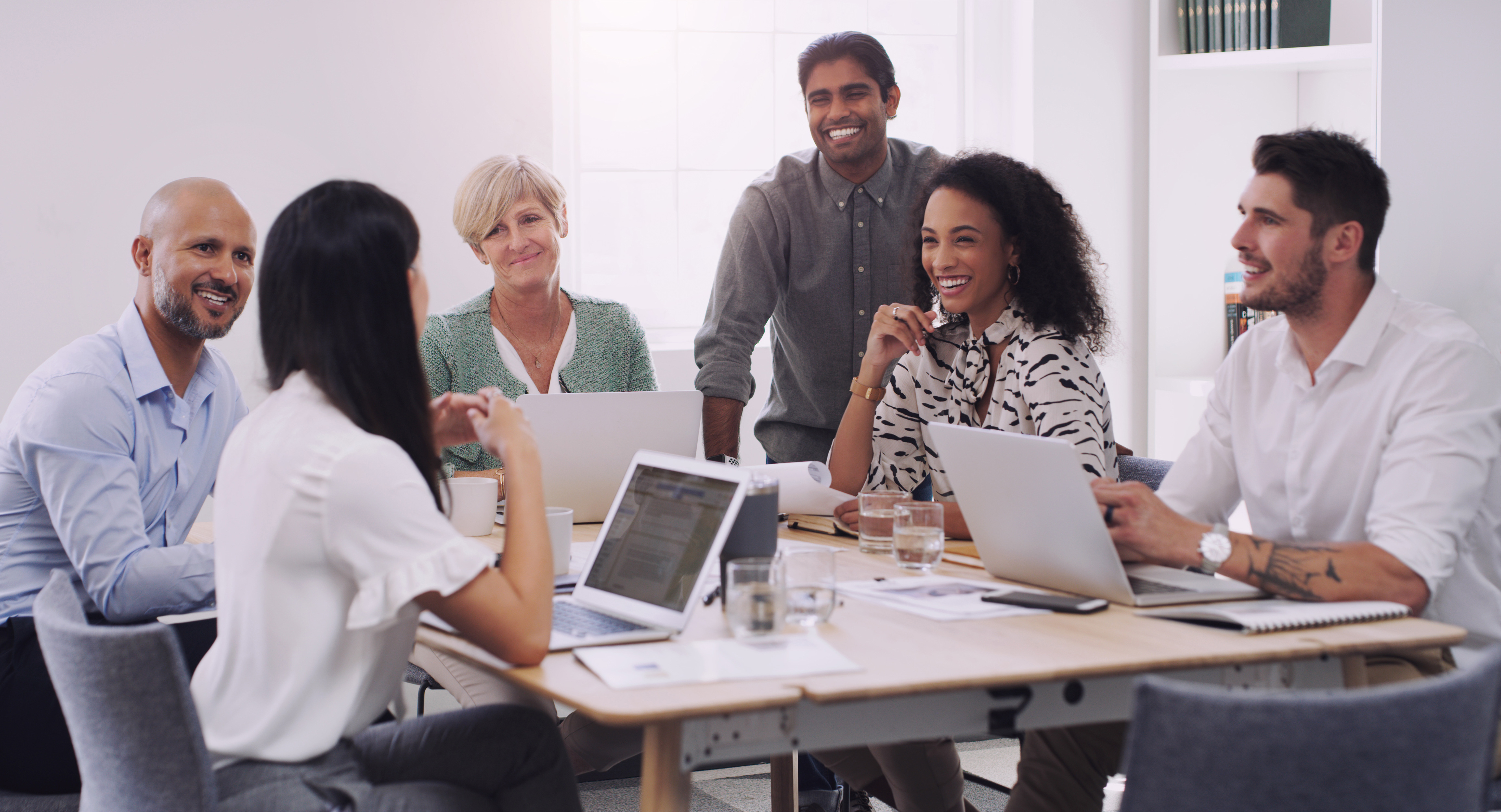 A leadership team gathered around a conference table in an open, light-filled working session